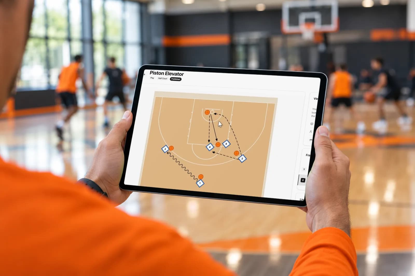 Тактическая доска для баскетбола SpotBasket на iPad у площадки с анимированной комбинацией на половине поля